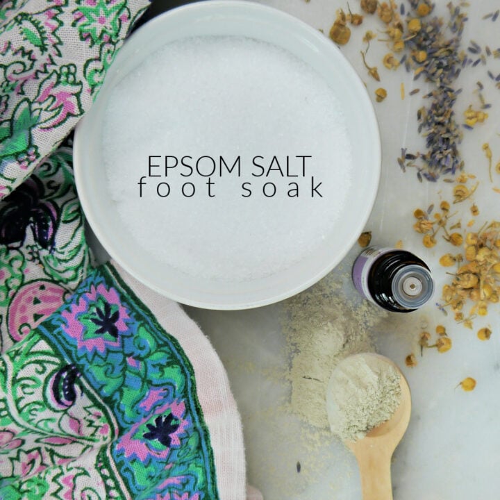 Colorful napkin with a white bowl with salt, a wooden spoon with clay and a bottle of essential oils.