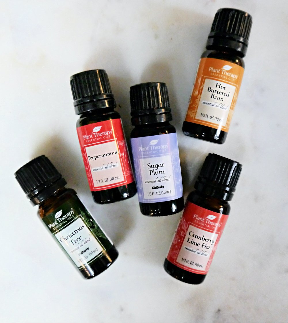 5 Holiday Essential Oil Blends on a marble tray.
