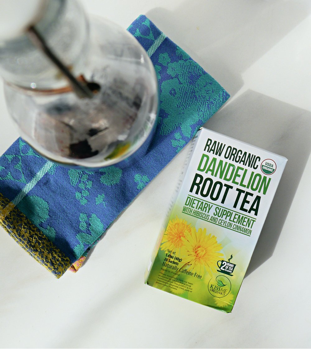 Box of Dandelion Root tea and glass bottle on blue cloth napkin.