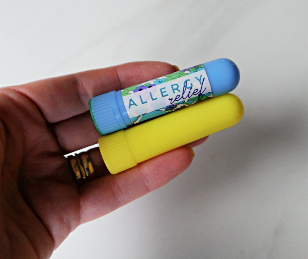 Blue and yellow plastic inhaler in a hand. 