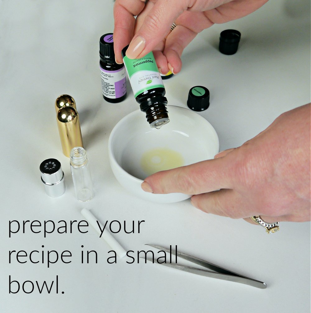 Hand dropping peppermint essential oil into white bowl.