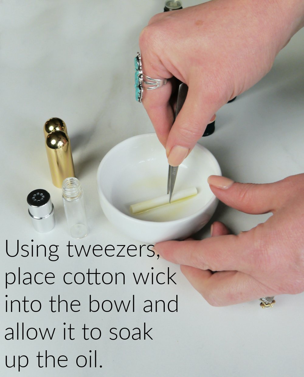 Hands placing cotton wick in white bowl with tweezers.