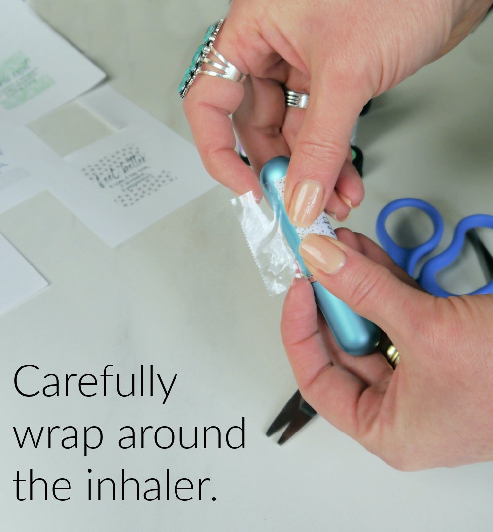 Hands wrapping label around the inhaler.